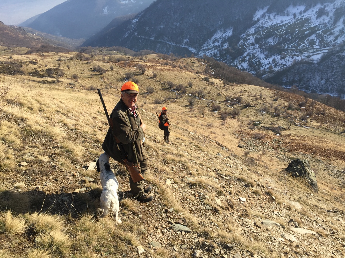 Cacciatore con cane da ferma sui pendii montani